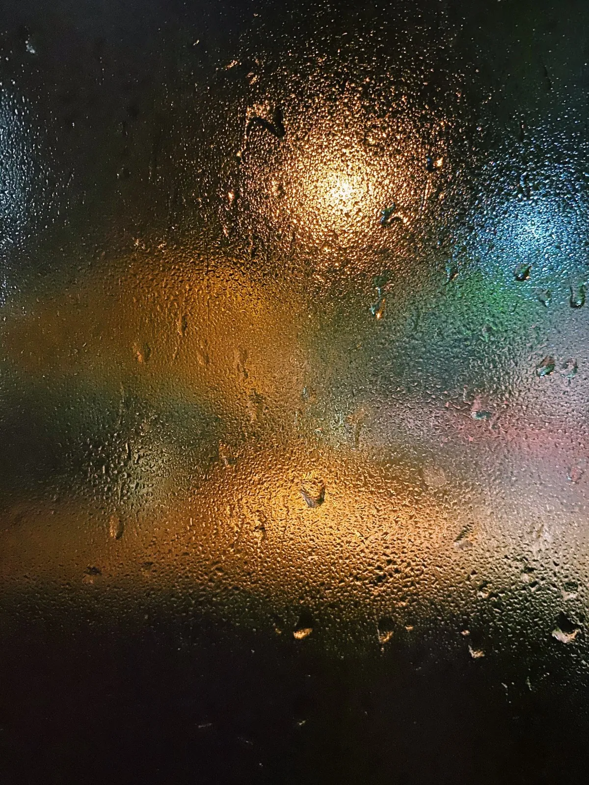 City lights through a rain-covered window at night